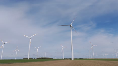 Spinning-wind-turbines-on-wind-farm-towers,-sustainable-power,-electricity-production