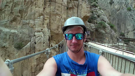 Vista-Selfie-Caminando-Sobre-Un-Puente-De-Cable-En-Medio-De-Acantilados-Rocosos-Sobre-El-Río