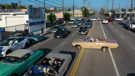 Aerial-view-following-old-low-riders-on-the-streets-of-sunny-Los-Angeles,-USA