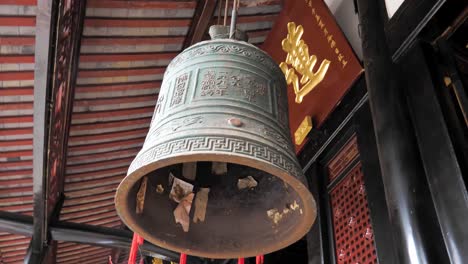 Large-brass-bell-hanging-under-the-roof-in-Wenshu-monastery,-Chengdu,-China