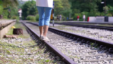 Woman-balancing-herself-at-the-train-track-in-slow-motion