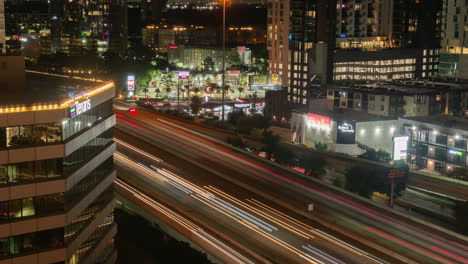 Night-time-lapse-of-busy-traffic-and-downtown-buildings,-Houston-Texas