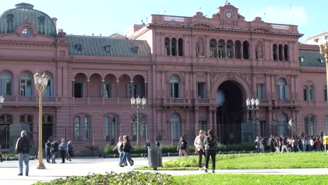 Wide-view-of-pedestrians-passing-by-the-Casa-Rosada,-Argentina's-Presidential-Palace