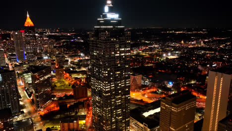 Aerial-approaching-flight-of-Truist-Plata-Tower-and-magnificent-city-of-Atlanta-lighting-at-midnight
