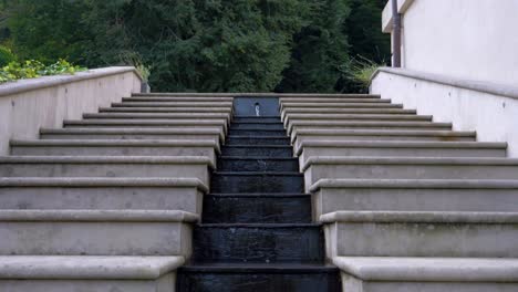 In-Der-Mitte-Befindet-Sich-Ein-Stufenförmiger-Wasserbrunnen,-Der-Den-Stufen-Folgt