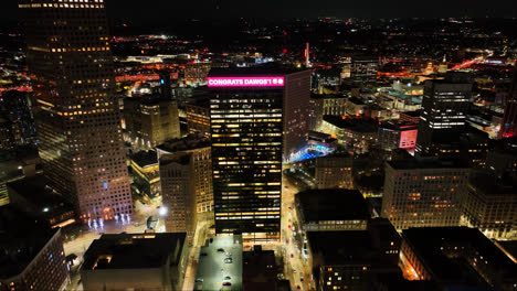 Aerial-view-showing-lighting-Congrats-Dawgs-billboard-on-skyscraper-building-in-city-of-Atlanta-at-night