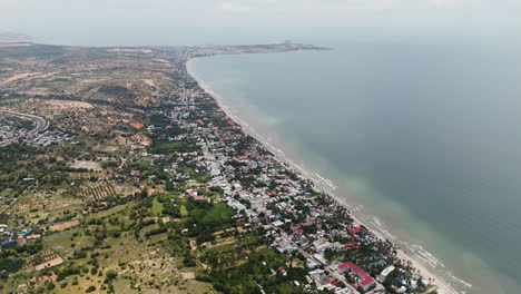 High-angle-aerial-panoramic-overview-of-Mui-Ne-beach-and-Ham-Tien-coastline,-Vietnam