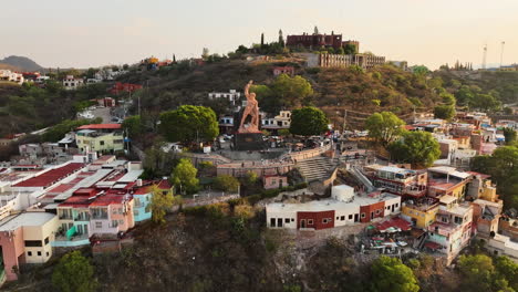 Aerial-view-around-the-El-Pipila-Statue,-golden-hour-in-Guanajuato-city,-Mexico