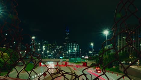 Timelapse-of-Chicago-trough-metal-grid-fence-at-night
