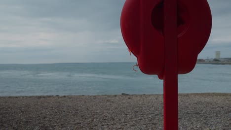 Static-slow-motion-shot-of-a-life-preserver-on-a-beach-in-Southsea