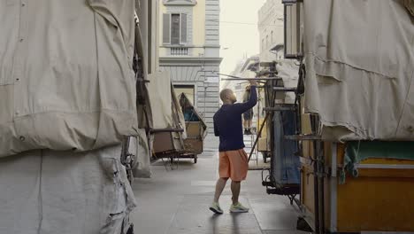 Street-vendor-preparing-his-booth-in-the-historical-leather-market-of-Florence