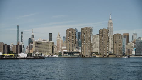 Ship-Passing-Manhattan-Skyline-on-East-River,-New-York-City,-USA