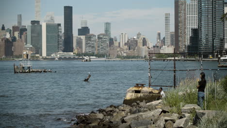 Zwei-Junge-Erwachsene-Blicken-Von-Der-Brooklyn-Waterfront,-New-York,-Auf-Die-Skyline-Von-Manhattan