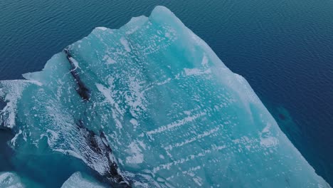 Vista-Aérea-Sobre-Un-Iceberg-En-El-Agua-Glacial-Del-Lago-Jokulsarlón,-En-Islandia,-Durante-El-Invierno