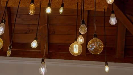 Decorative-light-bulbs-hanging-from-wooden-ceiling,-warm-atmosphere