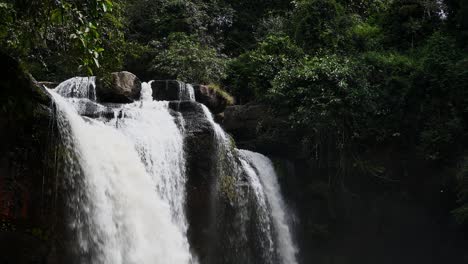 A-timelapse-of-a-wafting-mist-in-front-of-the-cascading-Heo-Suwat-Waterfall,-inside-Khao-Yai-National-Park,-a-UNESCO-World-Heritage-Site-in-Nakhon-Ratchasima-province-in-Thailand