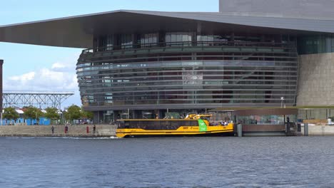 Edificio-De-La-Ópera-De-Copenhague-Con-Gente-Y-Taxi-Acuático-Amarillo-Delante---Dinamarca