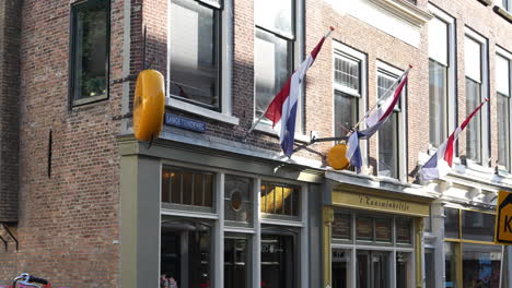 Banderas-Holandesas-En-El-Escaparate-De-Una-Tienda-De-Quesos-En-Gouda,-Países-Bajos