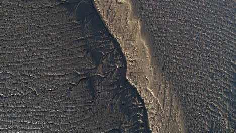 Drone-view-of-riverlets-and-creases-making-patterns-in-low-tide-mud-in-the-Seven-Estuary-UK
