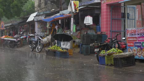 Street-vendors-during-heavy-rainfall-in-the-rural-Indian-town,-Wide-angle-shot