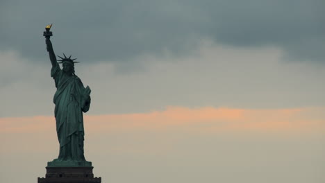 Estatua-De-La-Libertad-Al-Atardecer-Con-Nubes-Pasando-Lentamente