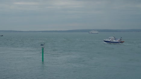 An-Einem-Bewölkten-Tag-Fahren-Boote-Im-Kanal-Herum,-Mit-Der-Isle-Of-Wight-Im-Hintergrund