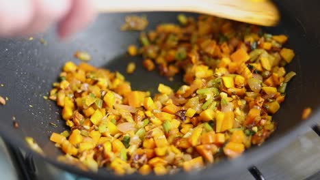 Cooking-And-Stirring-Chopped-Vegetables-In-Pan-With-Wooden-Spoon
