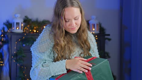 In-slow-motion,-young-woman-preparing-Christmas-gift-with-red-ribbon