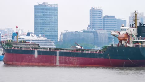 Cargo-ship-is-slowly-moving-across-the-Huangpu-River-in-Shanghai,-China