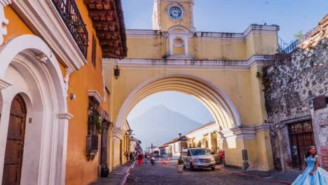 Time-lapse-of-cars-and-people-walk-below-Guatemala-archway-framing-mountain-behind