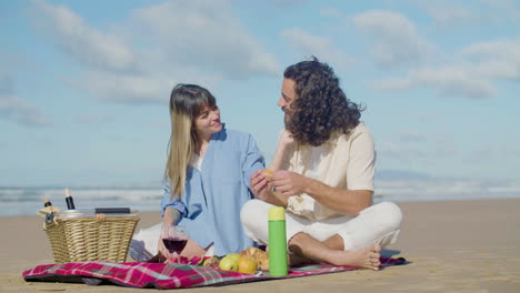 Beautiful-young-couple-having-picnic-on-the-beach