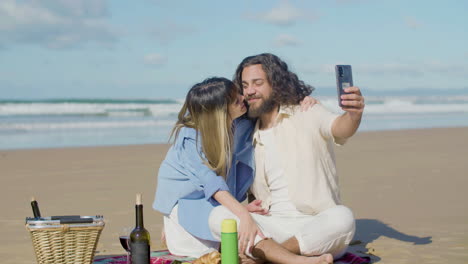 Pareja-Joven-Romántica-Tomando-Selfie-En-La-Playa