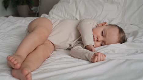Video-of-caucasian-little-baby-girl-sleeping-on-bed-at-home.