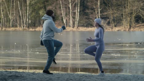 Wide-shot-of-adult-caucasian-couple-warming-up-before-winter-swimming.