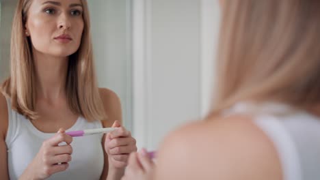 Junge-Frau-Steht-Vor-Dem-Badezimmerspiegel-Und-Wartet-Auf-Die-Ergebnisse-Des-Schwangerschaftstests.