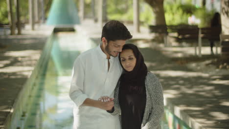 Glückliches-Muslimisches-Paar,-Das-Sich-Im-Park-Umarmt-Und-Händchen-Hält.