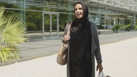 Schöne-Muslimische-Frau,-Die-Mit-Einkaufstüten-Auf-Der-Straße-Läuft.