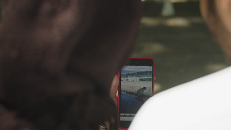 Close-up-of-muslim-couple-viewing-photos-on-smartphone-outside.