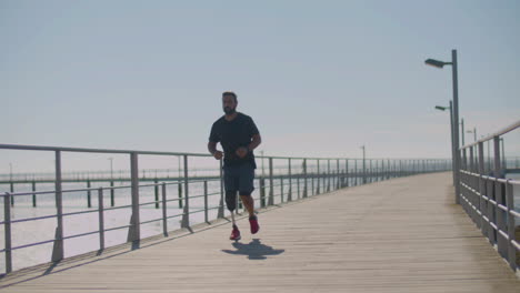 Strong-male-athlete-with-prosthetic-leg-jogging-on-bridge.
