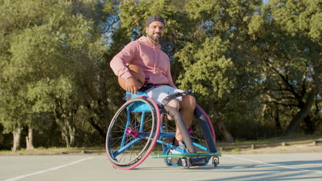 Happy-bearded-man-in-sports-wheelchair-at-basketball-court