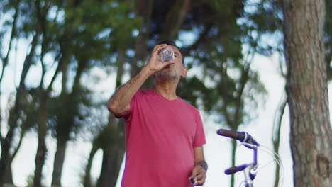 Caucasian-man-enjoying-drinking-water-after-cycling