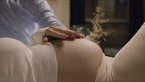 Pregnant-woman-and-her-husband-touching-and-stroking-belly