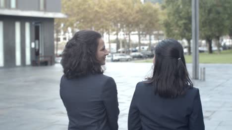 Rear-view-of-female-coworkers-going-from-work-and-talking