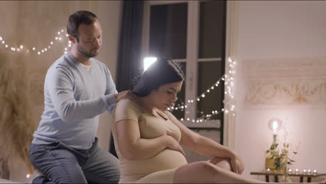 Caucasian-husband-massaging-shoulders-of-pregnant-woman