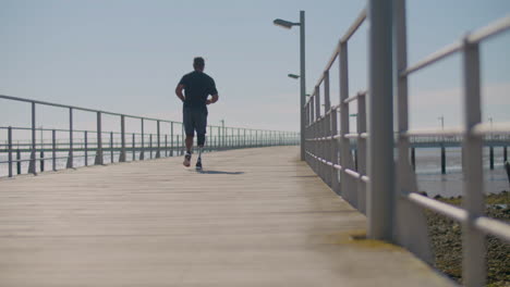 Strong-man-with-artificial-leg-jogging-on-bridge.