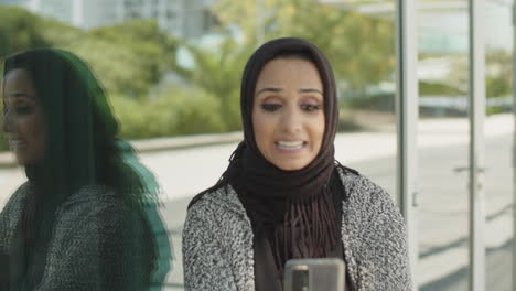 Close-up-of-young-muslim-woman-having-video-call-outdoors.