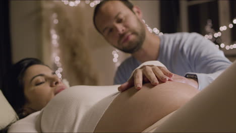 Pregnant-woman-and-her-husband-stroking-big-tummy-together