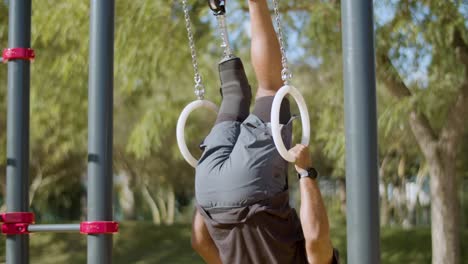Strong-man-with-artificial-leg-doing-gymnastic-rings-workout.