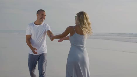 Happy-Caucasian-couple-having-fun-while-walking-at-seashore.