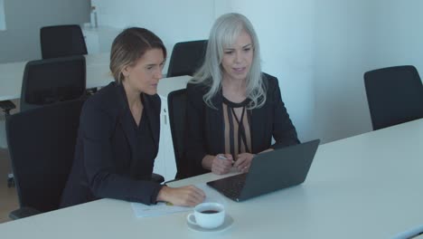 Zwei-Ernsthafte-Geschäftsfrauen-Nutzen-Laptop-Für-Videogespräche